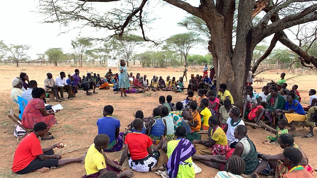 A community dialogue meeting under a tree in Karamoja